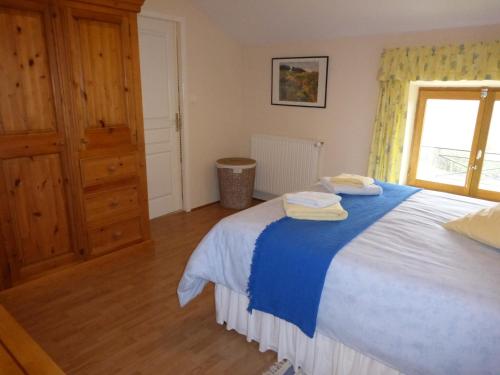 a bedroom with a large bed with towels on it at L'Hirondelle Chambres d'Hotes in Saint-Mathieu