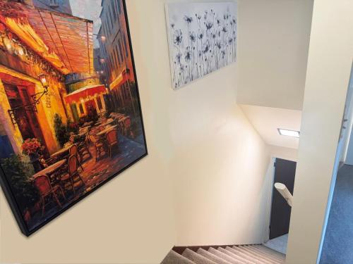 a painting hanging on a wall next to a staircase at Cute as HECK! in Tacoma