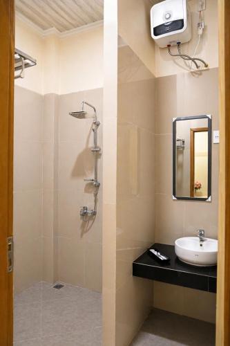a bathroom with a sink and a mirror at Hotel Grand Langkawi By ZIRI in Lheue