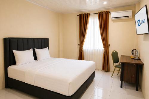 a bed in a room with a desk and a bed sidx sidx sidx at Hotel Grand Langkawi By ZIRI in Lheue