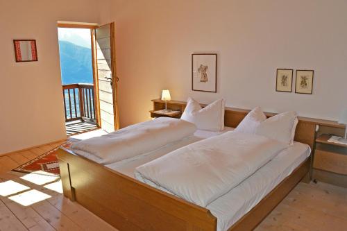 a bedroom with two beds with white pillows at Kohlstatt Hof Ferienhaus in Verano
