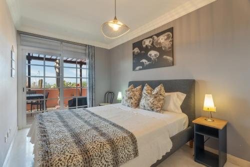 a bedroom with a king sized bed and a balcony at Apartamento Duque Beach in Adeje
