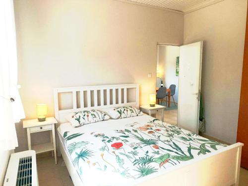 a bedroom with a bed with a floral bedspread at Bougainvillea Retreat above Faliraki in Kalithies