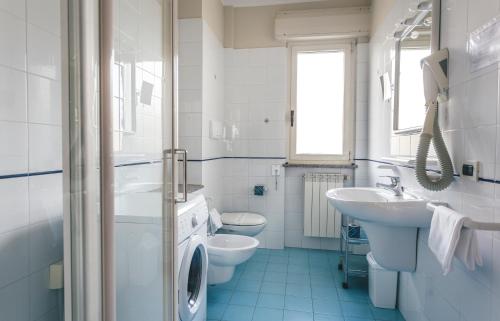 bagno bianco con 2 servizi igienici e lavandino di Hotel Principe Residence a Vasto