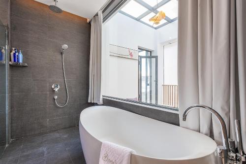 a bathroom with a bath tub and a window at 鹿野山房 DeerHoliday Inn in Dali