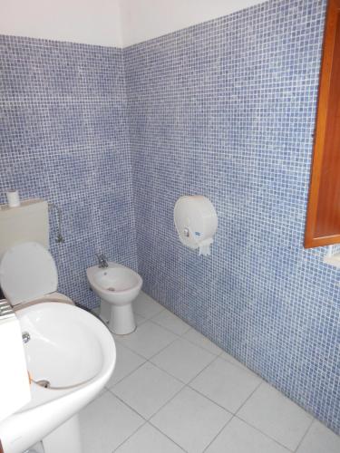 a blue tiled bathroom with a toilet and a sink at Casa de Hóspedes Celeste by Portugalferias in Odeceixe