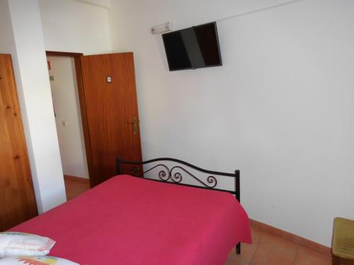 a bedroom with a red bed with a red blanket at Casa de Hóspedes Celeste by Portugalferias in Odeceixe
