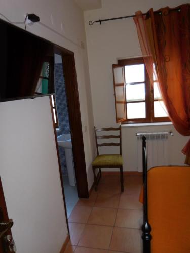 a room with a chair and a window and a mirror at Casa de Hóspedes Celeste by Portugalferias in Odeceixe