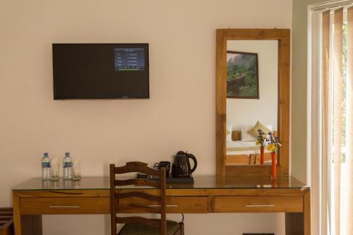 a desk with a television on a wall next to a mirror at Shalom Residence Kandy in Kandy