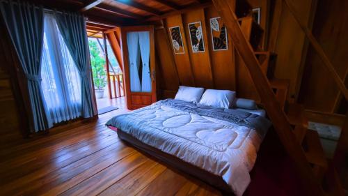 a bedroom with a bed with a wooden floor at Griya Yodesiya Resort Semarang in Karangjati