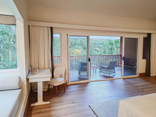 a bedroom with a bed and a desk and a balcony at Cloud Forest Lodge in Monteverde Costa Rica