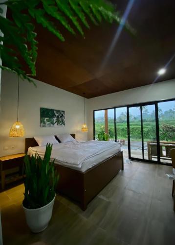 a bedroom with a bed and a large window at Tropical Aurora Tetebatu in Tetebatu