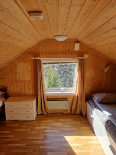 a room with a bed and a window in a cabin at Nordfjord Charm in Stårheim