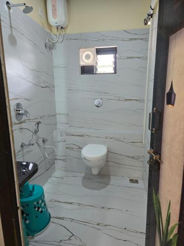 a white bathroom with a toilet and a sink at Ocean Mist Beach Homestay in Māvalli