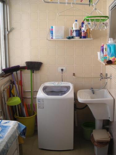 - une salle de bains avec une poubelle à côté d'un lavabo dans l'établissement Condominio Edifício Las Vegas, à Guarujá