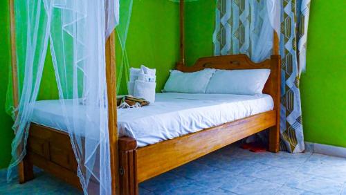a bedroom with a bed with a green wall at Tum Hotel & Conferencing in Mombasa