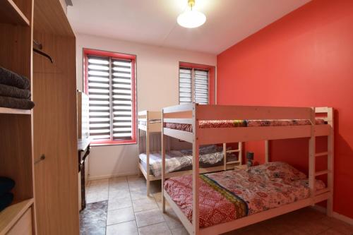 a bedroom with two bunk beds in a room with red walls at Sweet garden in La Fère
