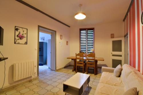 a living room with a couch and a table at Sweet garden in La Fère