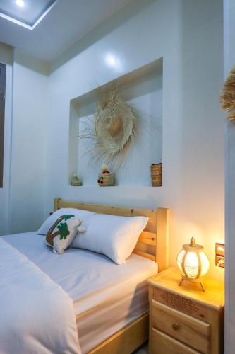 a bedroom with a bed with a shell on the wall at The Palm Surfhouse in Tamraght Ouzdar