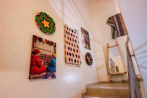 a room with a staircase with pictures on the wall at The Palm Surfhouse in Tamraght Ouzdar