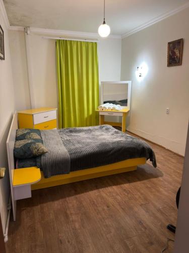 a bedroom with a bed and a green curtain at Msho Amroc in Aparan