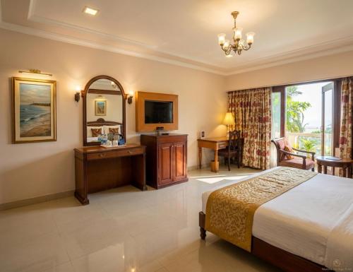 a bedroom with a bed and a desk and a mirror at Noor-Us-Sabah Palace in Bhopal
