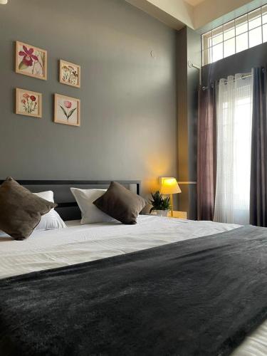 a bedroom with a large bed and a window at HO6 Homestay in Guwahati