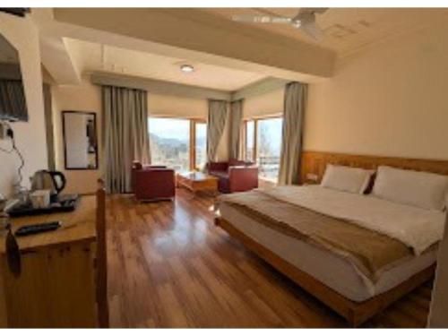 a bedroom with a large bed and a large window at Overland Heights - Near Leh Airport in Leh