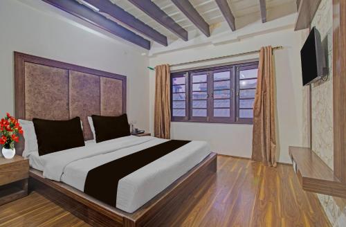 a bedroom with a large bed and a window at Collection O NIT Srinagar Formerly Main Street Inn in Srinagar
