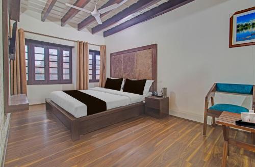 a bedroom with a large bed and a desk at Collection O NIT Srinagar Formerly Main Street Inn in Srinagar