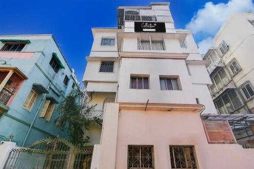 a tall white building with a sign on it at Collection O Lake Mall Kalighat Formerly Venkateshwara in Kolkata