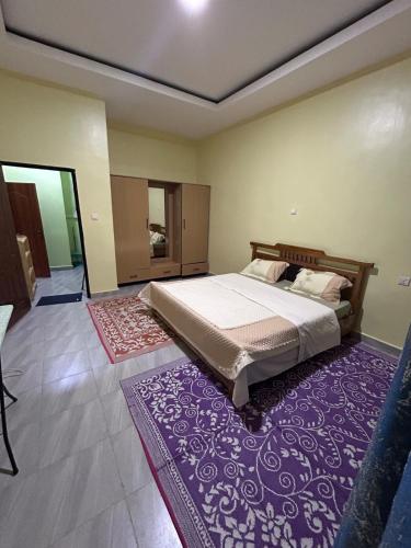 a bedroom with a bed and a purple rug at Ikamba Residence in Rwamagana