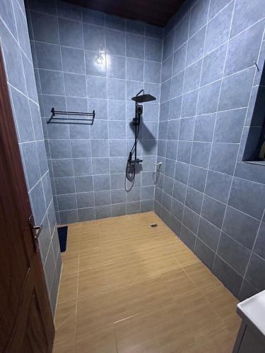 a bathroom with a shower with blue tiles at Ikamba Residence in Rwamagana