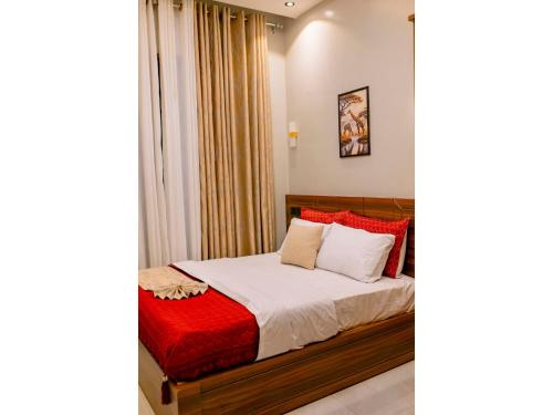 a bedroom with a bed with red and white pillows at Residency by Mozette Kigali in Kigali