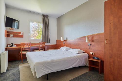 a hotel room with a bed and a table and chairs at CIT'HOTEL Armony Hotel in Bourg-Achard