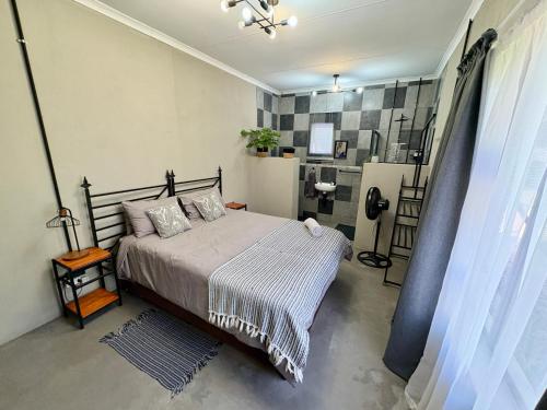 a bedroom with a bed and a shower at Stylish One Bedroom Garden Suite in Polokwane