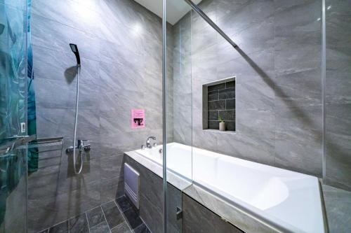 a bathroom with a tub and a sink and a shower at Enjoy Homestay in Tainan