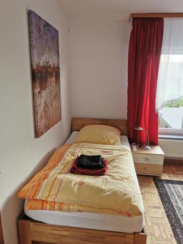 a bed in a bedroom with a red curtain at Schöne Ferienwohnung Wetzlar in Wetzlar