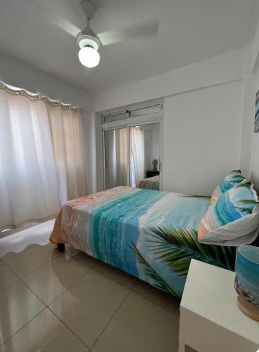 a bedroom with a bed with a colorful blanket at A pasos de la playa y el centro de Bayahibe in Bayahibe