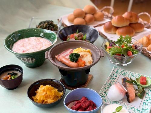 a table topped with bowls of different types of food at GLOBAL RESORT NUKUI in Akiota