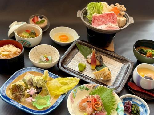 a table with plates of food and bowls of food at GLOBAL RESORT NUKUI in Akiota