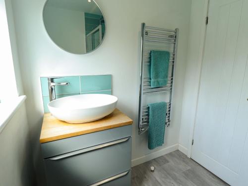 a bathroom with a sink and a mirror at Field View in North Walsham
