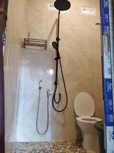 a shower in a bathroom with a toilet at Jay Guest House Gili Gede in Sekotong