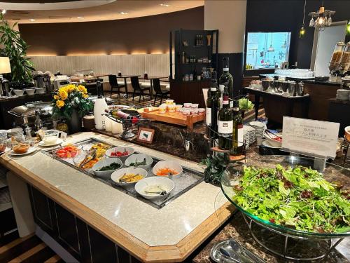 a buffet with food on a counter in a restaurant at Hotel Terrace the Garden Mito in Mito