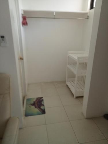 a small white room with a picture on the floor at J and M Pension House in Dipolog
