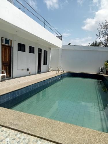 a swimming pool in the backyard of a house at J and M Pension House in Dipolog