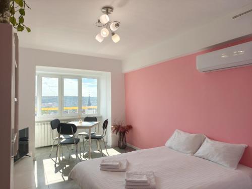 a bedroom with a bed and a table with chairs at Inima Iasului - Central View Apartment in Iaşi