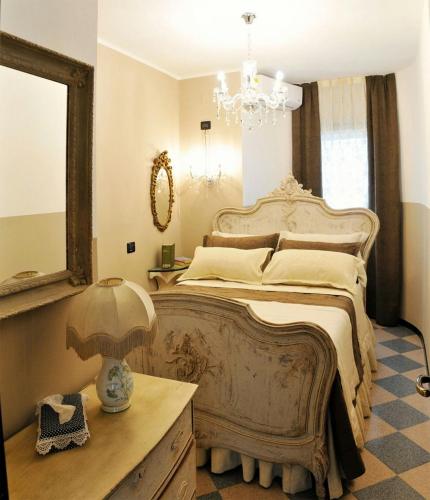 a bedroom with a large bed and a chandelier at Manor Villa Among Veneto's Orchards in Castelbaldo