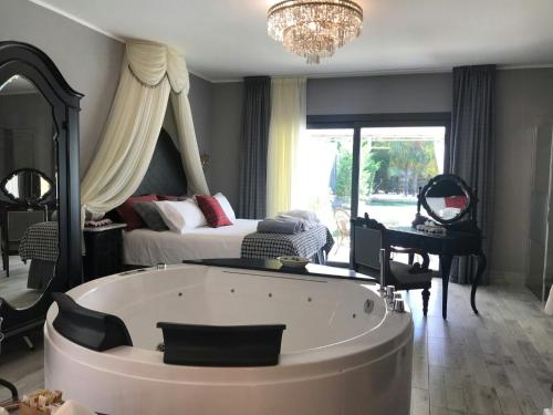 a large room with a bath tub and a bedroom at Manor Villa Among Veneto's Orchards in Castelbaldo