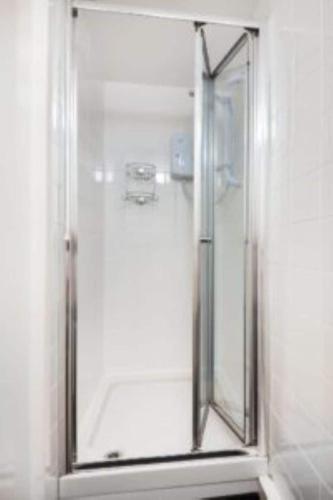 a shower with a glass door in a bathroom at Cilan in Llangian